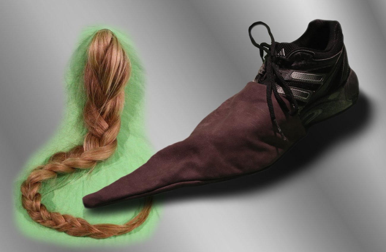 Blonde braid floats in a green highlight against a gradient of grey next to a Adidas shoe modified to appear as medieval footwear. 