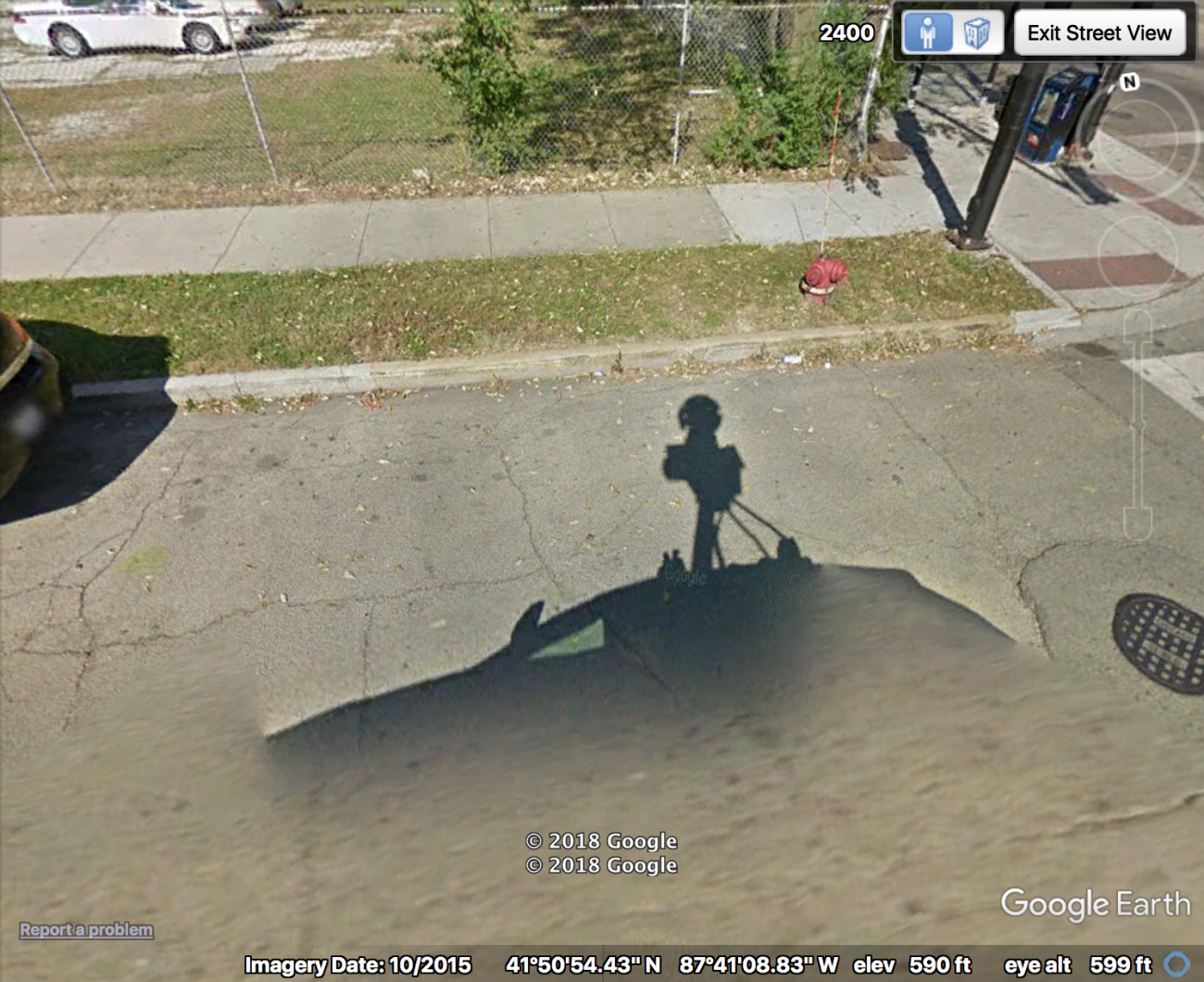 Image of a google satellite image showing the google maps car's shadow in the foreground. 