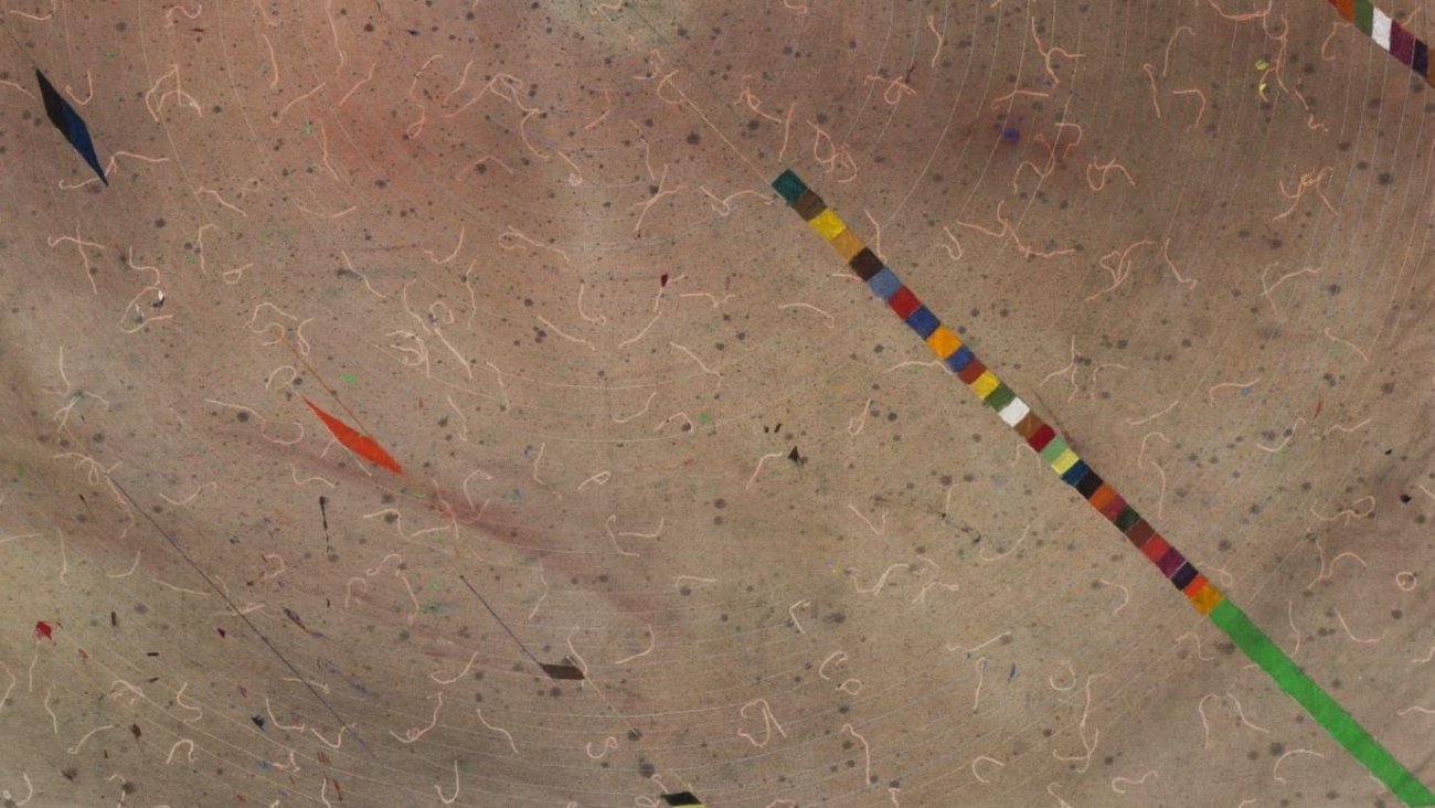 Looking down at a sidewalk with squiggly drawings and painted strip of colors