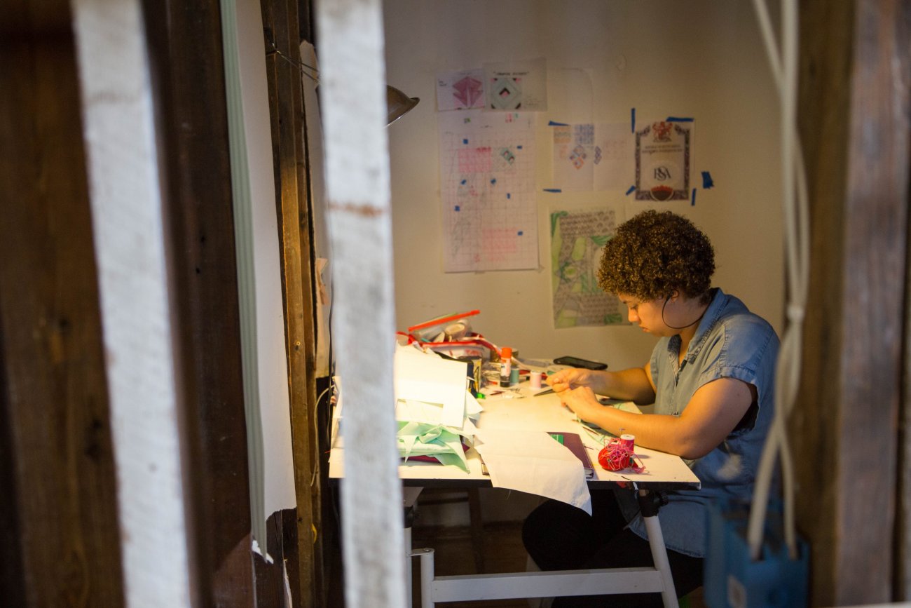 Artist drawing at desk in studio