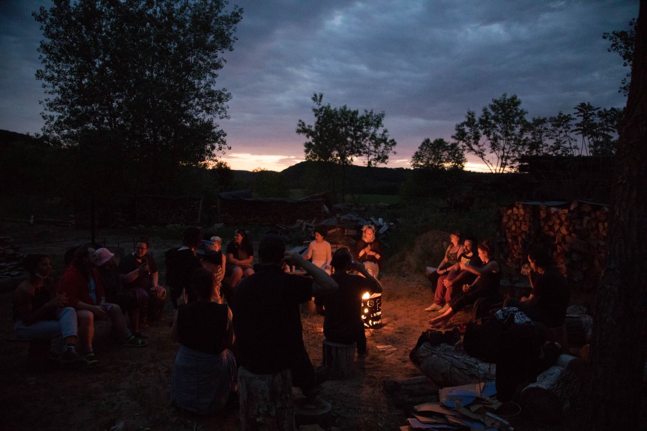 group gathered around fire at dusk