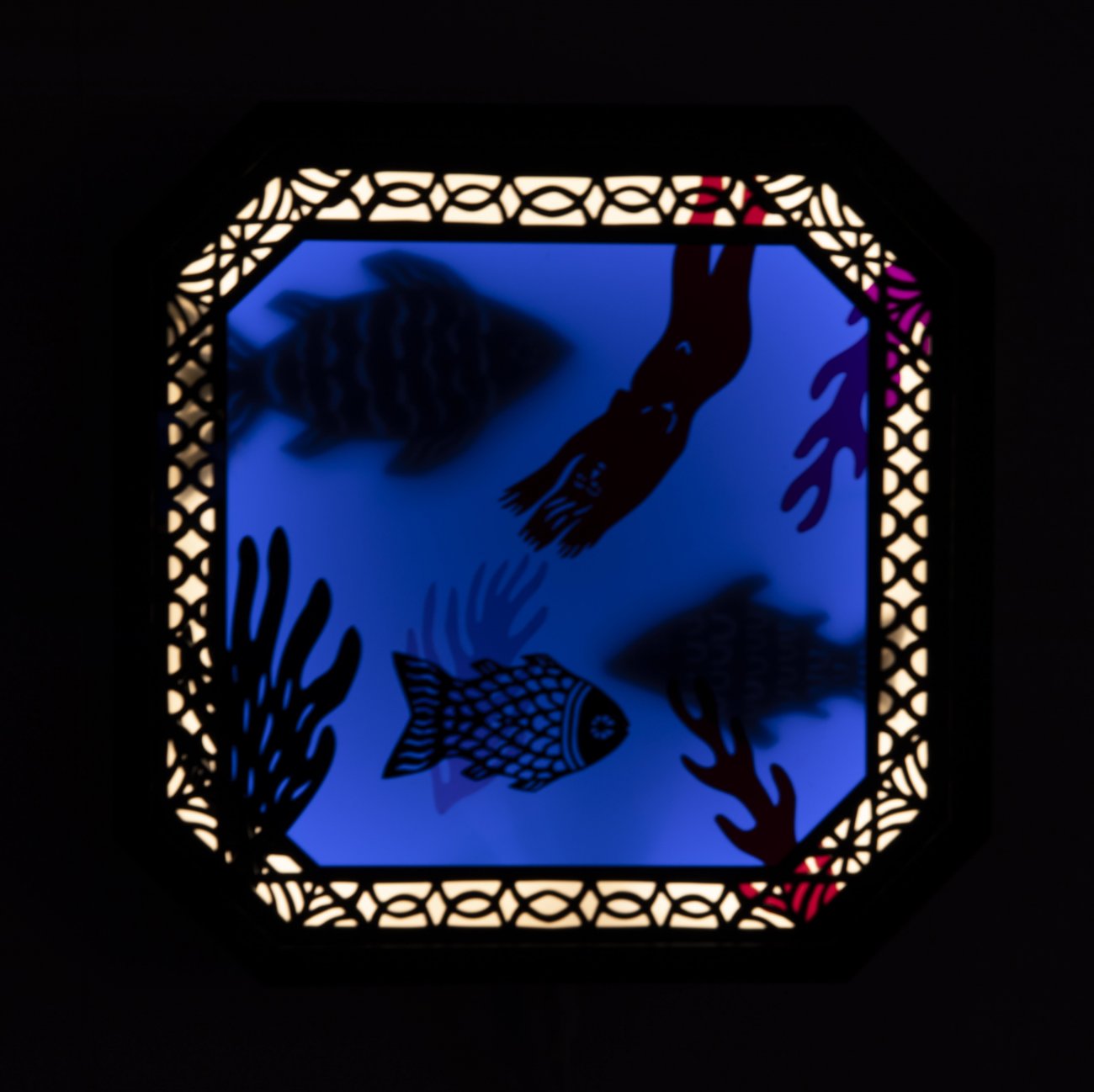Deep blue square shadows of flsh and sea life. A light border with a linework pattern and beveled edges goes around the work.