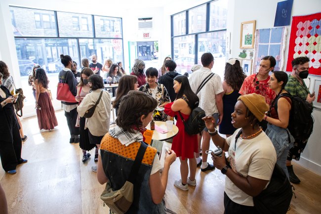 Group of people interacting in sunlit gallery space