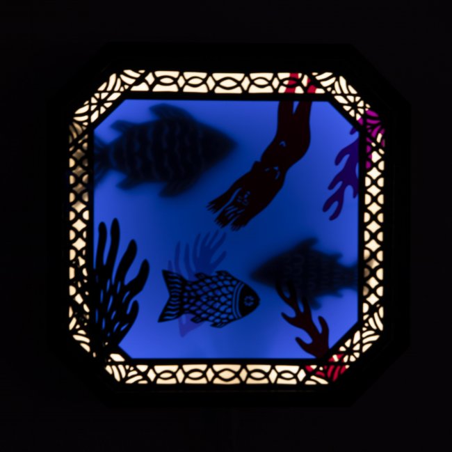 Deep blue square shadows of flsh and sea life. A light border with a linework pattern and beveled edges goes around the work.